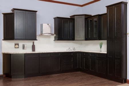 This charming kitchen features white shaker cabinets and drawers that contrast the sleek black appliances and is mediated by the gray marble countertop. Black All Wood Shaker Cabinets | Easy Kitchen Cabinets