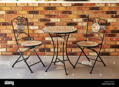 Table And Chairs Against A Backdrop Of Brick Wall Stock Photo Alamy