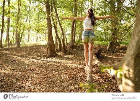 Young Woman In Forest Balancing On A Log A Royalty Free Stock Photo