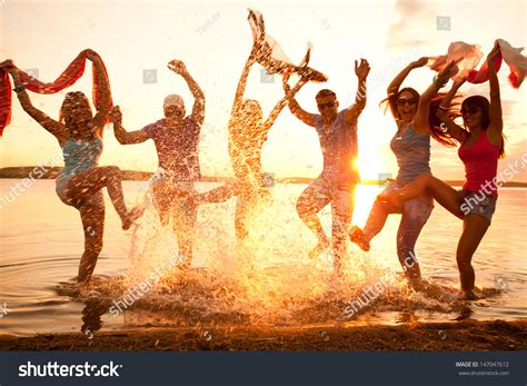 Large Group Of Young People Enjoying A Beach Party Stock Photo