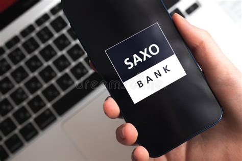 Saxo Bank App Trader And Broker Application Mobile Phone In Hand
