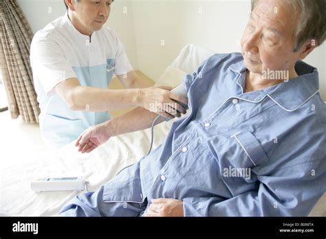 Male Nurse Taking Senior Mans Blood Pressure Stock Photo Alamy