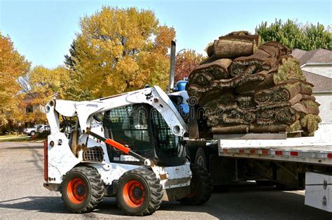 Bobcat Lifts A Pallet Of Sod Rolls From A Semi Trailer Editorial