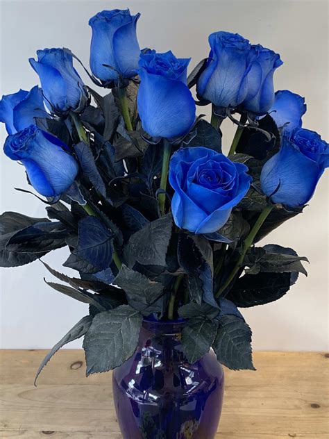 A Dozen Blue Roses Arranged In Blue Glass Vase W653 By Fillmore