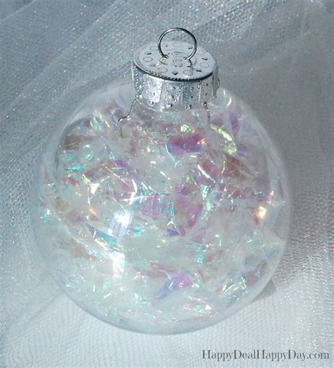 A Glass Ornament Filled With Lots Of White And Pink Confetti Pieces