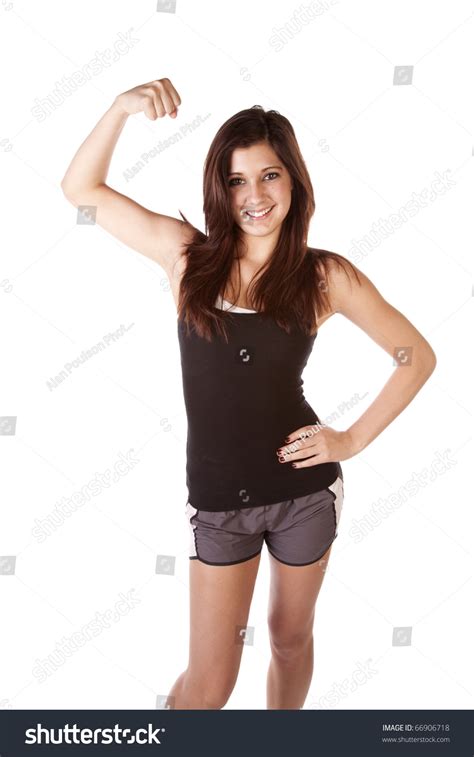 A Woman Showing Off Her Muscles By Flexing Her Arm With A Smile On Her