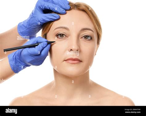 Plastic Surgeon Applying Marks On Woman S Face Against White Background Stock Photo Alamy