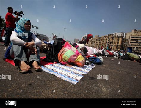 egyptians during performing their friday prayers while hundreds of egyptians demonstrate against