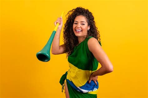 Jovem líder de torcida brasileira uma vuvuzela em fundo amarelo