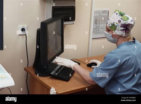 Una radióloga mujer detrás del monitor hace una corrección de rayos X Fotografía de stock Alamy