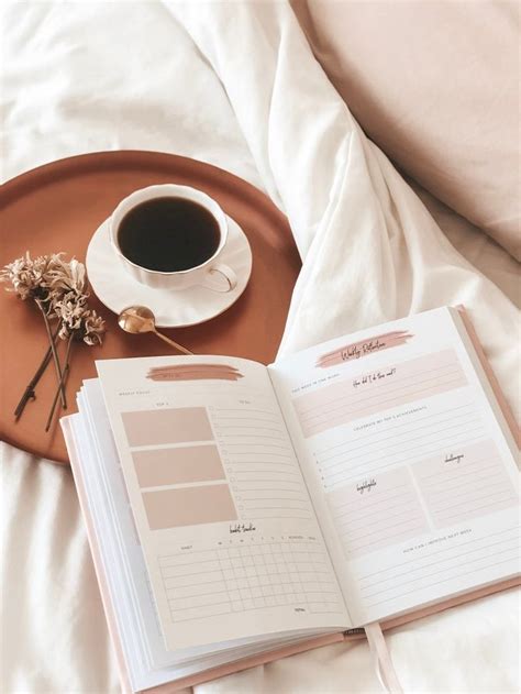 An Open Book On A Bed Next To A Cup Of Coffee And A Plant With Dried