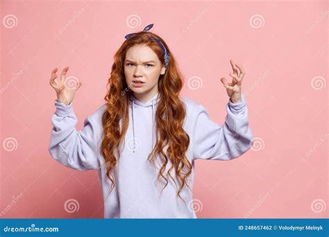 Angry Young Redhead Girl Student Looking At Camera Isolated On Pink