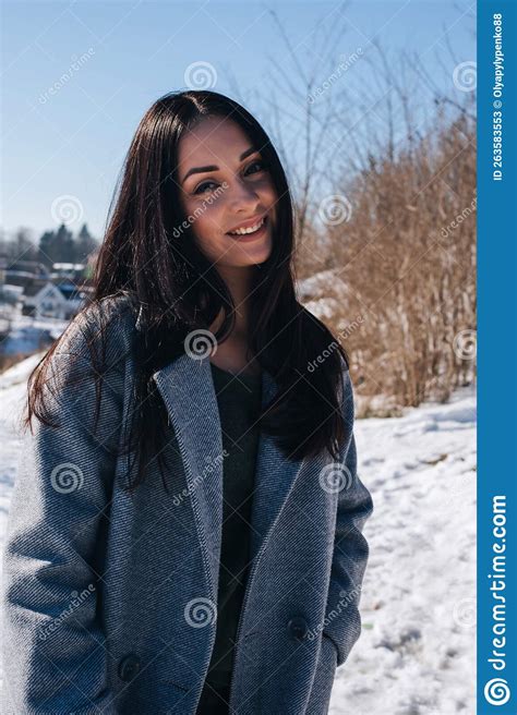 Portrait Of A Beautiful Dark Haired Girl With Brown Eyes On The Street In Snowy Winter Stock