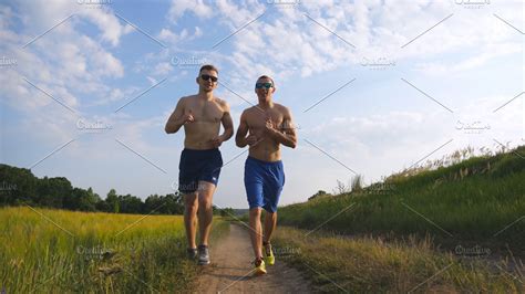 Two Muscular Men Running And Talking Outdoors Young Athletic Guys