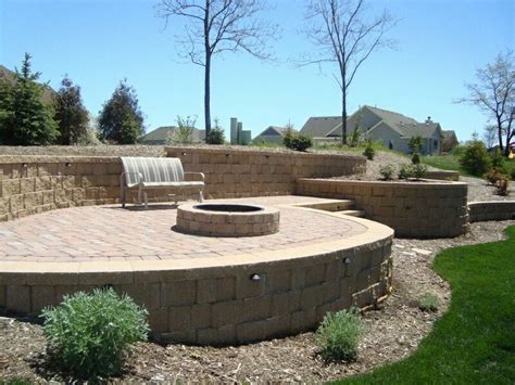 This connection means once you have your fire pit in place, there's no moving it. Curved retaining wall | Paver fire pit, Brick patios, Patio