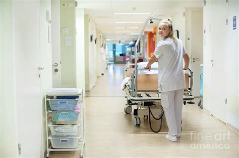 nurse pushing hospital bed in corridor photograph by arno massee science photo library pixels
