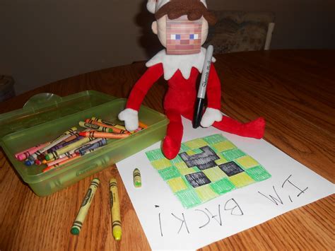 An Elf Is Sitting On The Table With Crayons Next To It And A Box Of Crayons