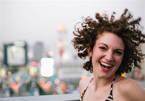 Happy Young Woman With Curly Hair Jumping Of Joy Del Colaborador De