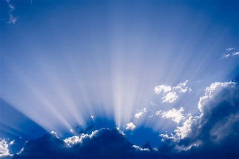 Rayos De Sol Que Se Levantan De Una Gran Nube En El Cielo Azul Intenso