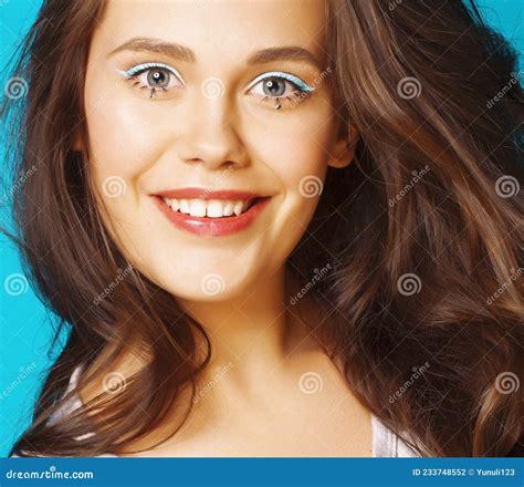 Young Pretty Adorable Brunette Woman With Curly Hair Closeup Like Doll Makeup On Blue Background