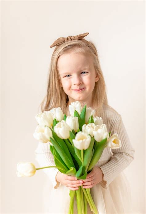 Beautiful Little Girl Holding A Bouquet Of White Tulips Stock Image