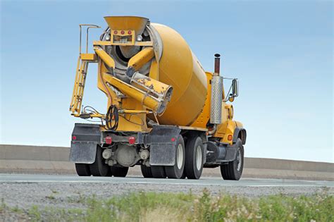 Yellow Cement Truck On Highway Delivering Concrete To Construction Site