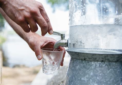Pouring A Drink Of Ice Water From A Spout By Stocksy Contributor