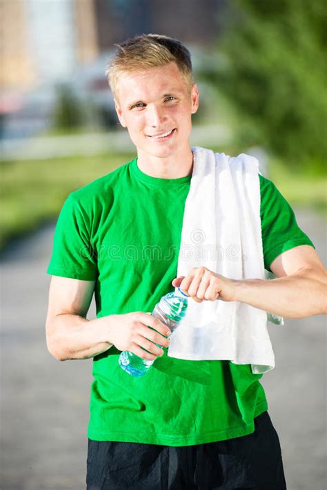 Tired Man With White Towel Drinking Water From A Plastic Bottle Stock