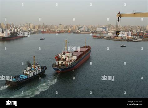 Small Bulk Carrier Assisted By Tugboat During Approaching Berth In Port