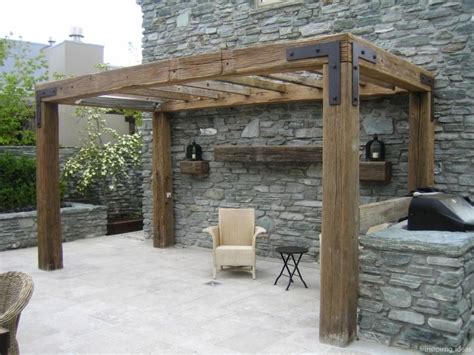 An Outdoor Living Area With Stone Walls And Wooden Pergolated