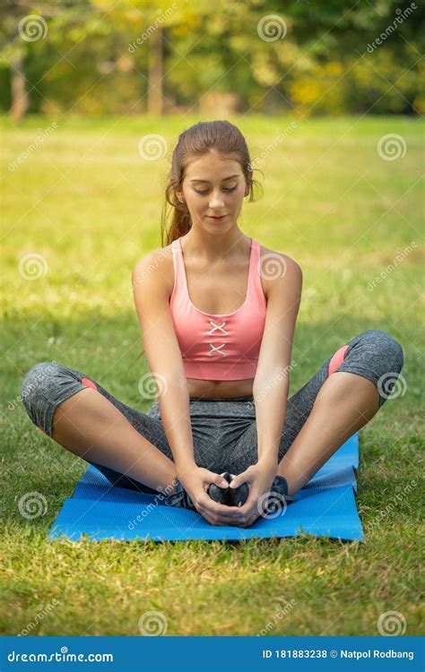 Young Fitness Woman Stretching Her Leg To Warm Up Sitting On Mat At