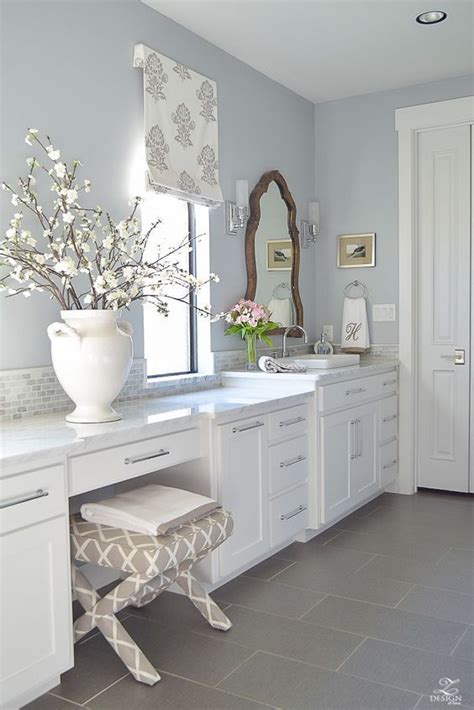An Image Of A Bathroom With White Cabinets And Gray Flooring On The