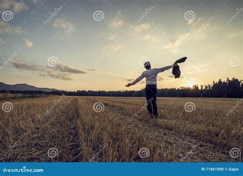 Man In Elegant Suit Standing In The Middle Of Cut Field Stock Photo