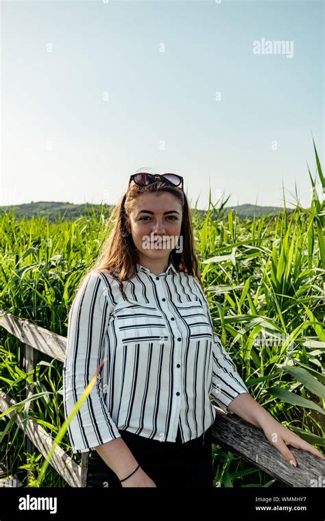 Beautiful Girl Through Reed Wearing A Striped Shirt Smiling And Having A Good Time At Reed