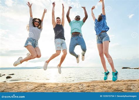 People Jumping On The Beach Stock Photo Image Of Lifestyle Happy