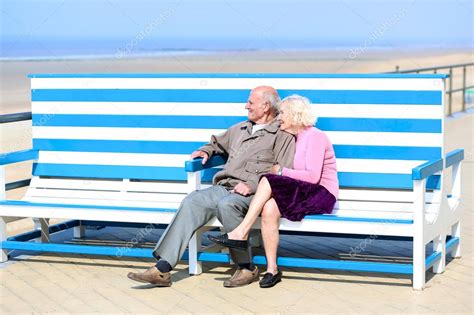 glücklich altes paar entspannenden an der Promenade auf der Bank sitzen Stockfoto CroMary