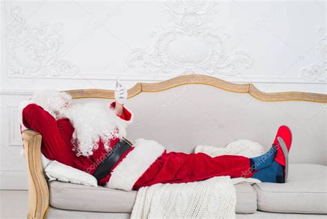Santa Claus Resting On A Sofa At Home — Stock Photo © Romankosolapov