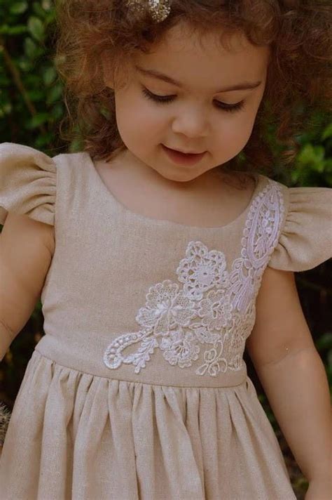 Muslin Dress With Flutter Sleeves And Lace Appliques That Create A
