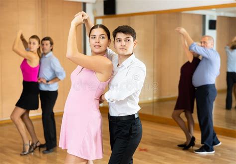 Cheerful Young Guy And Girl Practicing Ballroom Dances In Ballroom