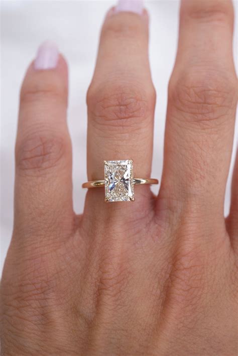 A Woman S Hand With A Diamond Ring On Top Of Her Finger And An