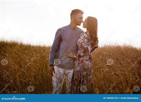 Beautiful Young Couple Kissing In A Field With Grass At Sunset Stylish Man And Woman Having Fun