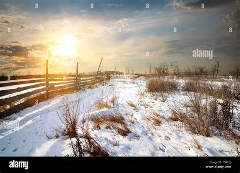 Wooden Fence In Winter Field At Sunset Stock Photo Alamy