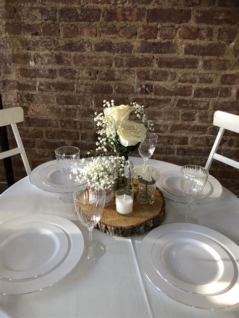 The Table Is Set With White Plates And Flowers