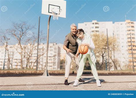 happy father and teenage daughter playing basketball outside at court stock image image of