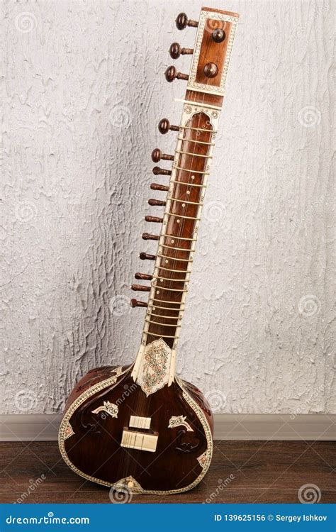 Indian Musical Instrument Sitar Standing Next To The Grey Wall Stock