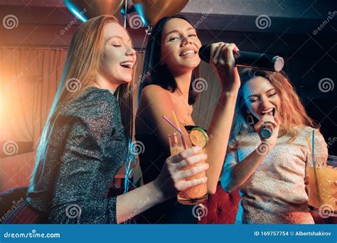 Cheerful Happy Friends Have Fun And Singing At Karaoke Party In Night