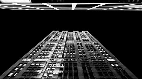 Black And White Shot Of Skyscraper From Below At Night With Windows And
