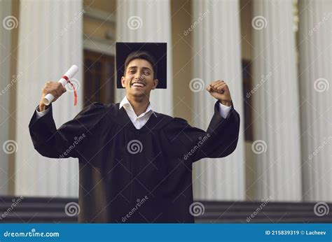 Happy University Graduate Standing With Diploma In Hand And Expressing