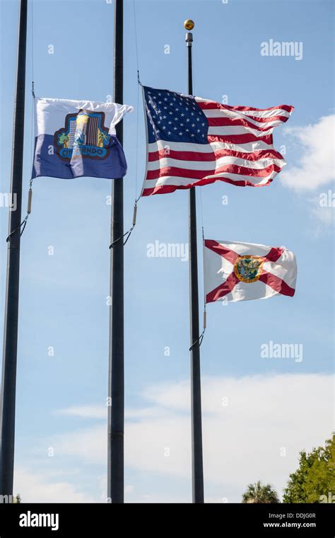 Us City Of Orlando And Florida State Flags Flying At Half Mast At Lake