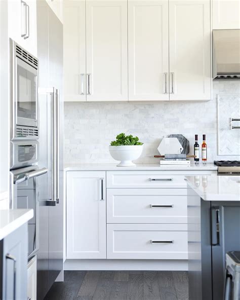 Shaker style kitchen with white cabinetry and black appliances. Amanda Evans on Instagram: "I love this kitchen! White shaker panel cabinets + a dark grey ...